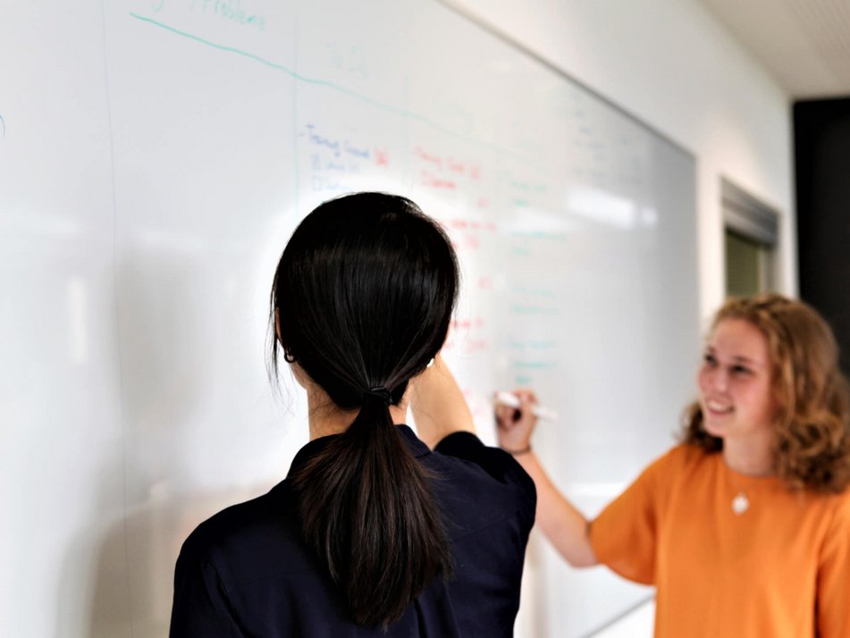 Jinq-Ching arbeitet mit Kollegin am Whiteboard