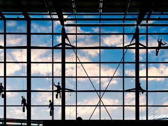 Eine große Fensterfront, die geputzt wird.
