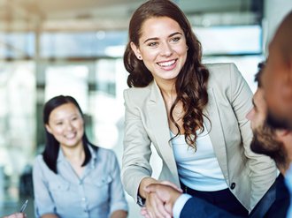 Frau im Büro begrüßt andere Personen.