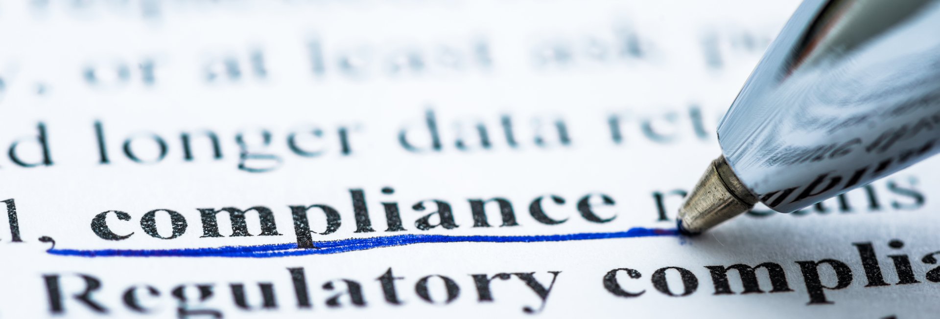 Das Wort compliance wird mit einem Stift unterstrichen