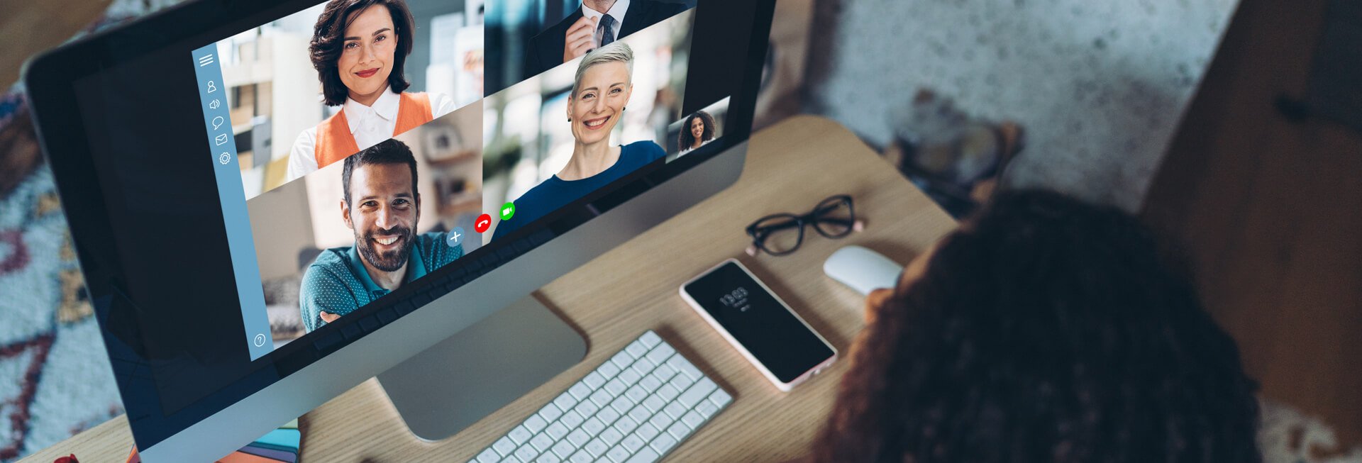 Frau sitzt am PC im Online-Meeting.